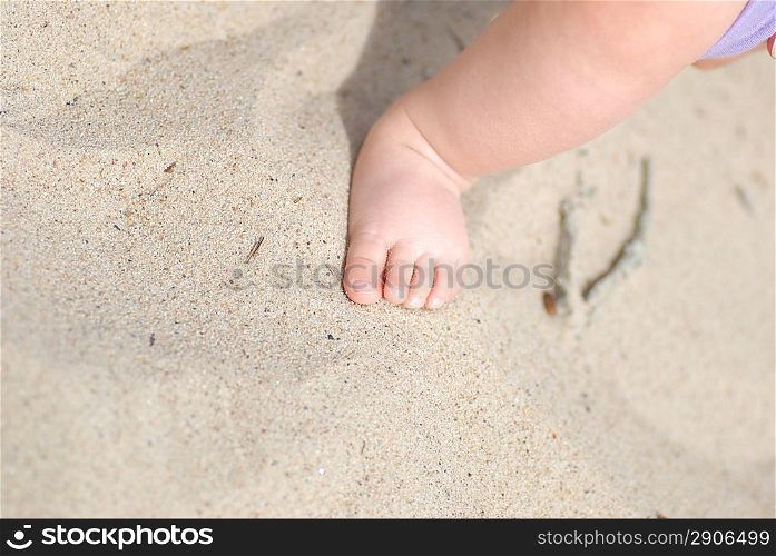 Children&acute;s foot on sea sand