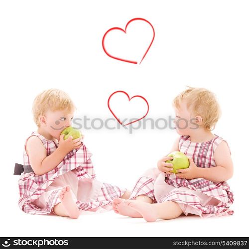 children and happiness concept - two adorable twins with apples over white