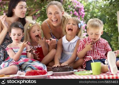Children And Mothers Eating Jelly And Cake At Outdoor Tea Party