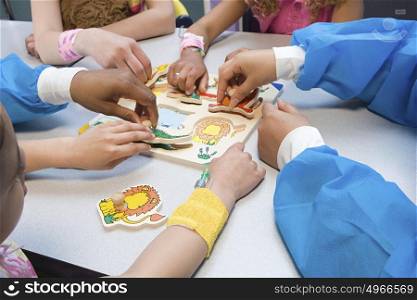 Children and nurses playing with puzzle