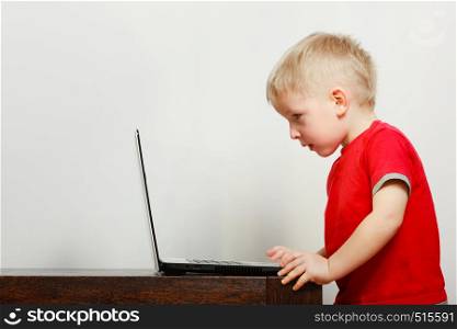 Children and technology, spending free time online concept. Little boy using laptop computer playing games. Little boy using laptop computer playing games