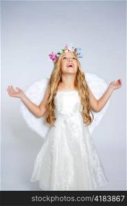 Children angel girl looking up sky with open hands and white wings