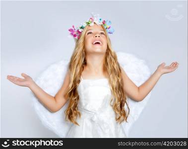 Children angel girl looking up sky with open hands and white wings