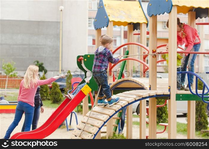 Children are playing at the playground outdoors. Children at the playground