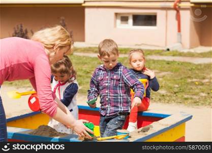Children are playing at the playground with sand in the sandbox