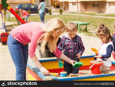 Children are playing at the playground with sand in the sandbox. playing in the sandbox
