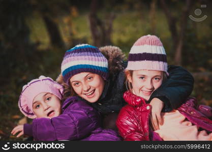 Children are playing with dry autumn leaves. Sisters on the walk