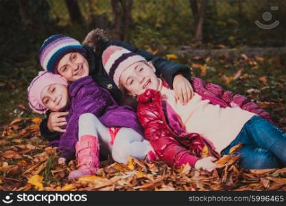 Children are playing with dry autumn leaves. Sisters on the walk