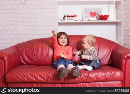 Children are sitting with Valentine day decorations. Valentine day decorations