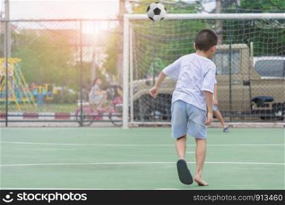 Children are wearing slippers playing football With blurred background to show movement.To exercise After school.