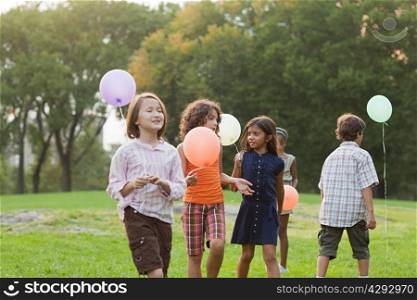 Children at birthday party holding balloons
