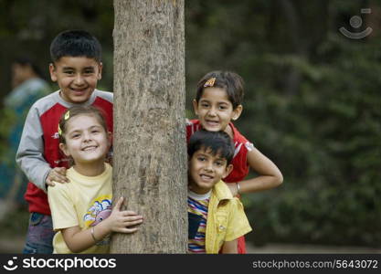 Children behind a tree