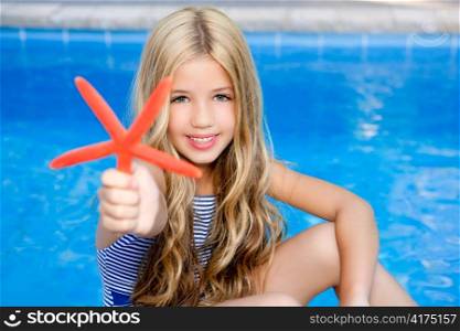 children blond girl in summer vacation pool with starfish