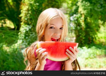 Children blond little girl eating watermelon slice in outdoor forest