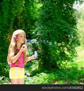 Children blowing soap bubbles in outdoor forest with fashion pink flower