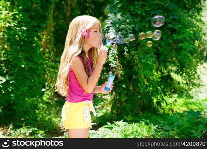 Children blowing soap bubbles in outdoor forest with fashion pink flower