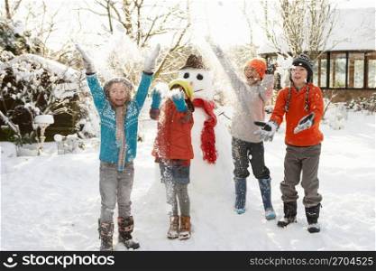 Children Building Snowman In Garden