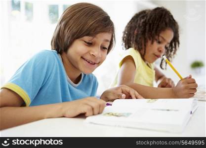 Children Doing Homework In Kitchen Together