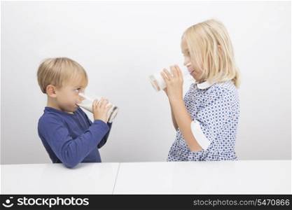 Children drinking milk while looking at each other