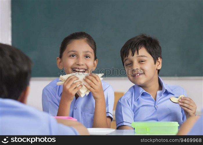 children eating sandwich in lunch in class