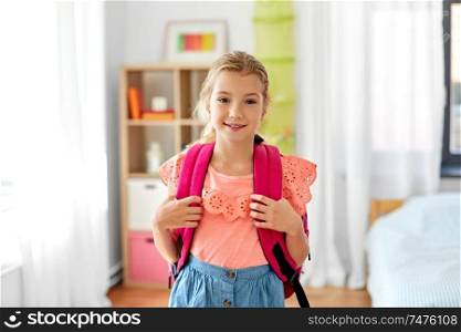 children, education and learning concept - happy student girl with school bag at home. student girl with school bag at home