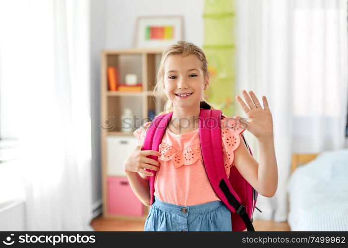 children, education and learning concept - happy student girl with school bag waving hand at home. student girl with school bag at home waving hand