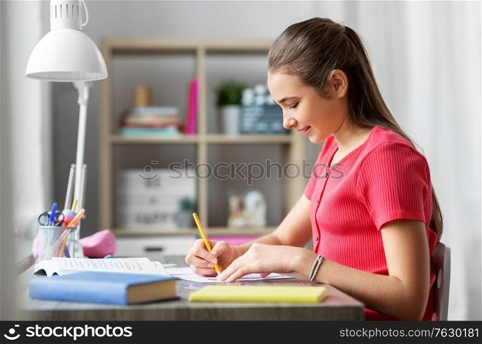 children, education and learning concept - student teenage girl with ruler drawing line in notebook at home. student girl with ruler drawing line in notebook