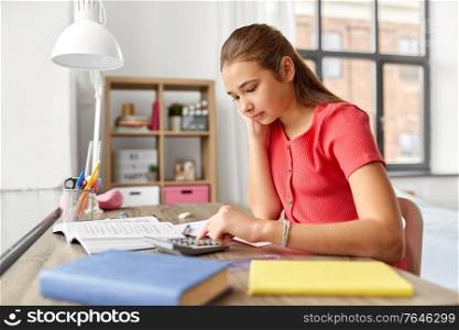 children, education and learning concept - teenage student girl counting on calculator at home. student girl counting on calculator at home