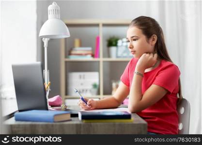 children, education and learning concept - teenage student girl with laptop computer at home. student girl with laptop computer learning at home
