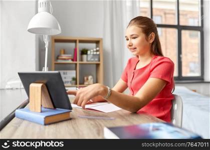children, education and learning concept - teenage student girl with tablet pc computer and notebook at home. student girl with tablet pc learning at home