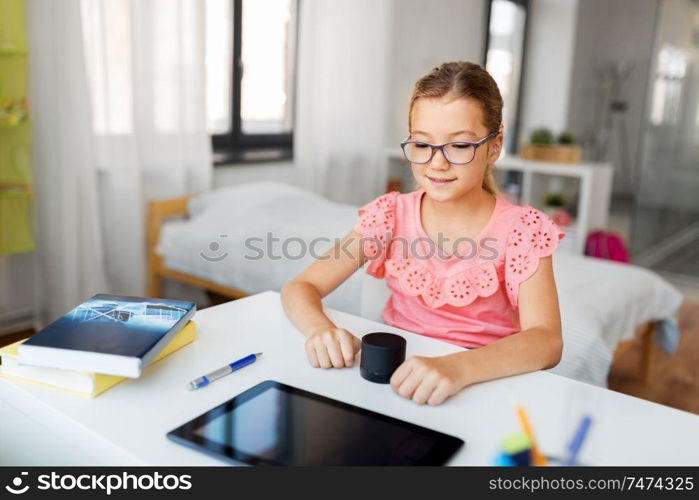 children, education and technology concept - student girl using smart speaker at home. student girl using smart speaker at home