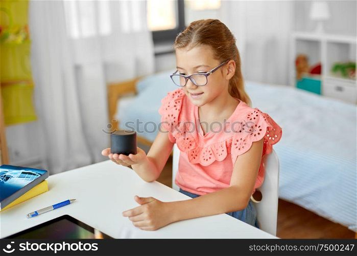 children, education and technology concept - student girl using smart speaker at home. student girl using smart speaker at home