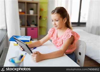 children, education and technology concept - student girl using tablet computer at home. student girl using tablet computer at home