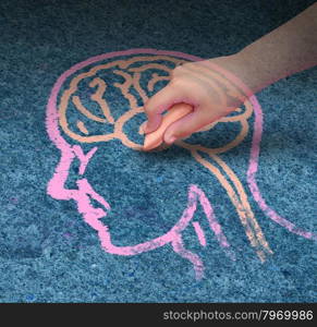 Children education concept and school learning development with the hand of a child drawing a human head and brain with chalk on a cement floor as a symbol of mental health issues in youth.