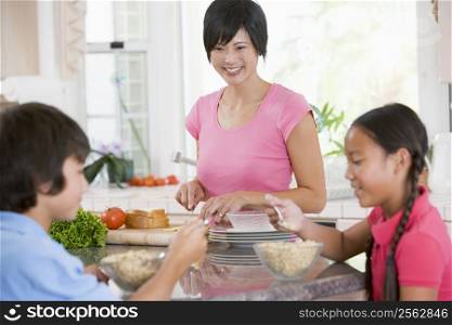Children Enjoying Breakfast While Mother Is Preparing Food