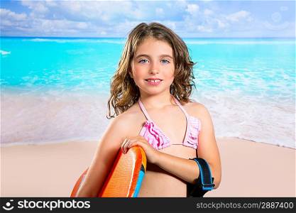 Children fashion surfer girl in tropical turquoise beach vacation smiling