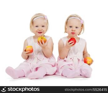 children, food and twins concept - two identical twin girl playing with apples