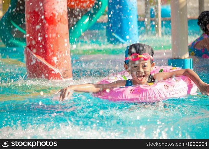 Children frolic at the water park. It is a sunny, perfect day for getting wet and playing hard.