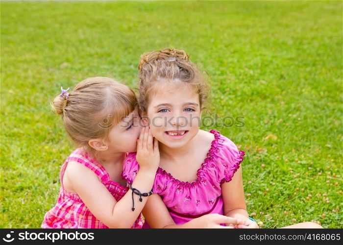 children girl sister friends whispering ear in green grass park