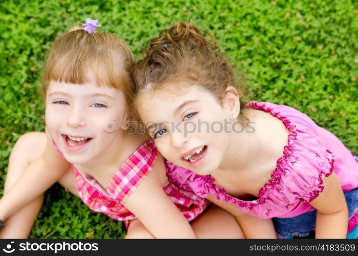 children girls laughing sitting on green grass park