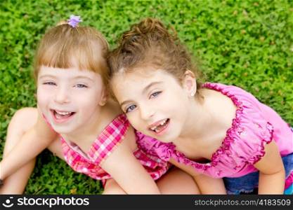children girls laughing sitting on green grass park