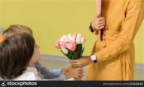 children giving their teacher bouquet flowers