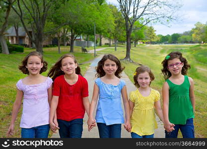 Children group of sisters girls and friends walking happy in the park outdoor