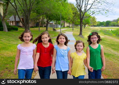 Children group of sisters girls and friends walking happy in the park outdoor