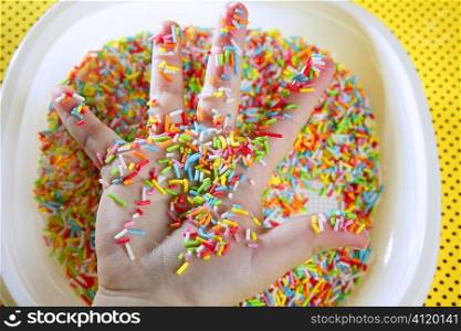 Children hand full of little colorful sweets