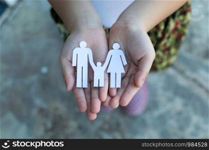 Children hands holding small model of heart and family , concept family