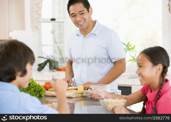 Children Having Breakfast While Dad Prepares Food