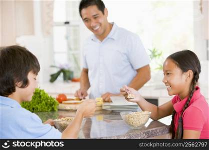 Children Having Breakfast While Dad Prepares Food