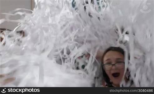 Children having fun time at paper party. They playing and frolicking in the heap of white confetti