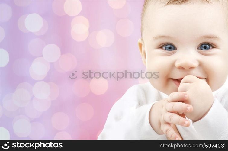 children, holidays, people, infancy and age concept - happy baby over pink lights background